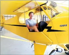  ?? Photo by Clarence Easley ?? Dane Hilger, a student at Gravette High School, sits in the seat of a training aircraft, a 1946 Piper J-3, in August. Hilger realized a dream of his and learned to fly in the plane.