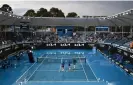  ?? Photograph: Joel Carrett/EPA ?? Attendants sweep attempt to sweep the rain from the court on Tuesday after a downpour in Melbourne.