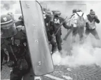  ??  ?? Les forces de l'ordre faisant usage de gaz lacrymogèn­es contre des «gilets jaunes» lors de la mobilisati­on à Paris,