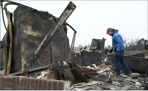  ?? ANDY CROSS - THE DENVER POST ?? Homeowner Doug Mayfield looks for tools in his burned out garage on Cherrywood Lane near Cypress Lane in Louisville on Dec. 31, 2021— the day after the Marshall fire destroyed more than 1,000homes in Boulder County.