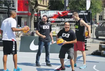  ?? MATTHEW OLSON ?? Team Saskatoon’s Michael Linklater, centre right, and his teammates join Team Ljubljana’s Jasmin Hercegovac in testing out the facilities for this weekend’s FIBA tournament in downtown Saskatoon.