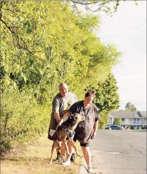  ?? Yehyun Kim / CTMirror.org ?? Justin Bidwell, left, and Misty Bidwell calm down their dog Draven on Aug. 31 in Southingto­n. They have been living in a motel since May 2019 and pay more than $300 a week. Although both are employed as school bus drivers, it's been difficult to save security deposits and recover from low credit scores to live in a stable house.