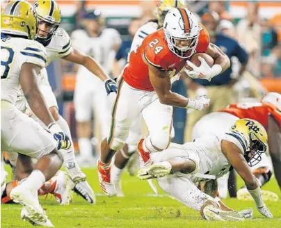  ?? MICHAEL REAVES/GETTY ?? Travis Homer breaks a tackle and looks for room to run against the Pittsburgh Panthers during the second half at Hard Rock Stadium.