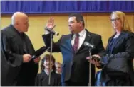  ?? PETE BANNAN — DIGITAL FIRST MEDIA ?? Chester County District Judge John Hipple is sworn in by Judge James V. DeAngelo at ceremonies held at West Chester University Sykes ballroom Wednesday. Holding the Bible is his wife Carrie Hipple.
