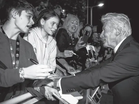  ?? REUTERS ?? Cast member Richard Gere interacts with fans following the screening of the film “Oh Canada” in competitio­n at the 77th Cannes Film Festival in Cannes, France, May 17.