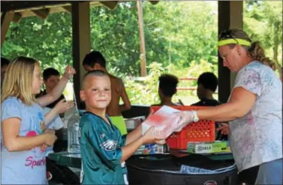  ?? MICHILEA PATTERSON — DIGITAL FIRST MEDIA ?? Children stand in line a to get a free boxed lunch at Pottstown Memorial Park. The free meals are part of the federally funded Summer Food Service Program and is organized in locally by the Pottstown Parks and Recreation Department.