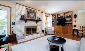  ?? ?? The family room is anchored by a delightful fireplace with a wooden mantel.