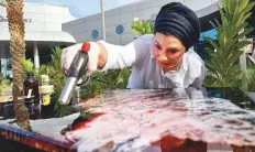  ?? Ahmed Ramzan/Gulf News ?? Contempora­ry artist Dina Khataan, an exponent of fluid and resin art, at the art festival yesterday.