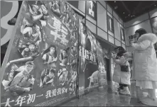  ?? SUN KAIFANG / FOR CHINA DAILY ?? People look at movie posters at a cinema in Shapingba, Chongqing, on Sunday.
