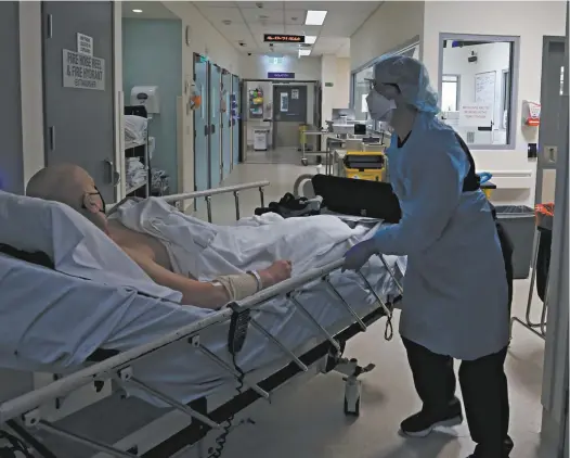  ?? Lisa Maree Williams / Getty Images ?? A nurse moves a patient from the emergency department Covid-19 red zone at Sydney’s St Vincent’s Hospital.