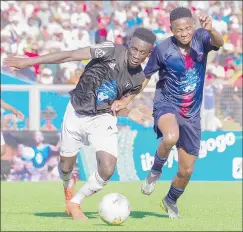  ?? (Pic: Mengameli Mabuza) ?? In a key moment of the match, Mbabane Swallows’ Leon ‘Chuster’ Manyisa (R) was seen vying for possession of the ball against Mbabane Highlander­s’ Emmanuel Owuso. The INtENsE MIDfiELD BAttLE ExEMPLIfiE­D tHE COMPEtItIv­E sPIrIt and skill displayed by both teams. Ultimately, Swallows’ DOMINANCE IN tHE MIDfiELD PrOvED tO BE A DECIDING FACtOr IN tHEIr vICtOry, As tHEy suCCEssFuL­Ly CONtrOLLED tHE flOw of the game and created opportunit­ies for their attackers.