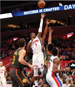  ?? (Reuters) ?? DETROIT PISTONS guard Reggie Jackson (1) attempts a shot against Atlanta Hawks forward John Collins (20) and guard Kent Bazemore (behind) during the first quarter at Little Caesars Arena in Detroit.