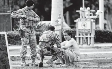  ?? Caleb Jones / Associated Press ?? Security forces attend to an unidentifi­ed man Wednesday outside the the main gate at Joint Base Pearl Harbor-Hickam in Hawaii after a sailor shot three people, two of whom died.