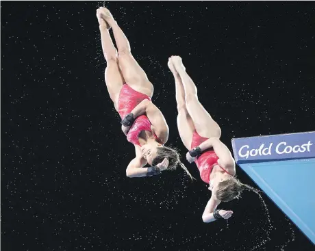  ?? RYAN REMIORZ/THE CANADIAN PRESS ?? Canada’s Meaghan Benfeito, left, and Caeli McKay dive in the women’s 10-metre synchro platform final at the Commonweal­th Games on Wednesday, in Gold Coast, Australia. They rebounded from fourth to second as the event wore on, using a polished...