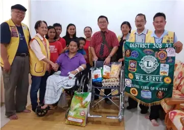  ??  ?? Sng (second left) presents the wheelchair and food stuffs to Simon. From left are Anthony, Simon, Moonly, Dr Sia and Stanley.