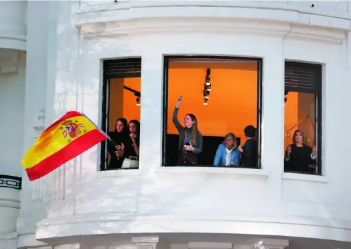  ?? LUIS DÍAZ ?? Un grupo de madrileñas ondea la bandera de España desde un balcón de la calle Génova