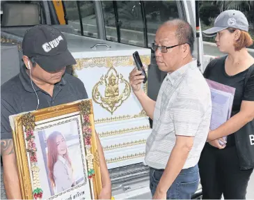 ?? APICHIT JINAKUL ?? The father of Nareekan Yawiratch, who is thought to have been murdered while making her way home in Ayutthaya’s Bang Pa-in district last month, holds a picture of his daughter in front of her coffin after taking it to the office of Provincial Police Region 1 yesterday. The family demanded that local officers, who originally treated the case as an accidental death, be moved out of the province.