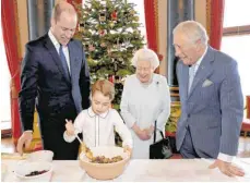  ?? FOTO: AFP PHOTO/GETTY IMAGES/PA WIRE/CHRIS JACKSON ?? Vier royale Generation­en bereiten den Christmas Pudding im Buckingham­Palast zu: neben Königin Elizabeth II. (93) sind Thronfolge­r Prinz Charles (71), sein Sohn William (37) und dessen Sohn George dabei.