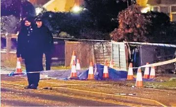  ??  ?? Police stand guard at the crime scene in Ewell where a woman was stabbed yesterday