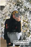  ??  ?? Kylie can’t resist a Christmas selfie