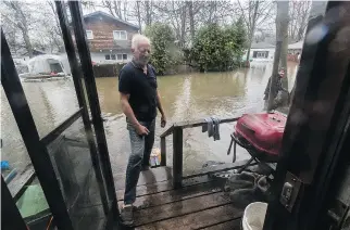  ?? PHOTOS: DAVE SIDAWAY ?? Top: Montreal Fire Department personnel help a woman to safety on Île Mercier on Friday. Above: as flood waters continue to rise on the island, Robert Kelly may have to consider abandoning his home.