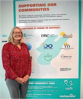  ?? ?? Deirdre Ryan, manager Community Wellbeing North Canterbury Trust, standing at the MainPower sponsorshi­p board.