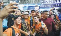  ??  ?? Mohd Faiz being mobbed by fans for selfies at KL Internatio­nal Airport yesterday.