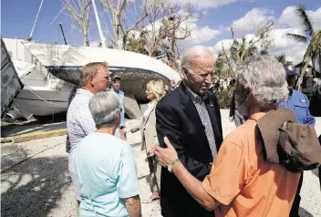  ?? EVAN VUCCI AP ?? President Joe Biden, center, talks to a person affected by Hurricane Ian as he tours the area on Wednesday in Fort Myers Beach, Fla.