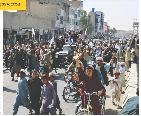  ?? AFP VIA GETTY IMAGES ?? Taliban supporters shout slogans and wave flags as they march in Kandahar on Tuesday, in celebratio­n of Monday's pullout of the final U.S. troops.