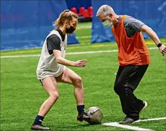  ?? Lori Van Buren / Times Union ?? Bethlehem soccer player Claire Hutton practices her ball-handling skills with her coach Tom Rogan during a team practice at Afrim's in Bethlehem in March.