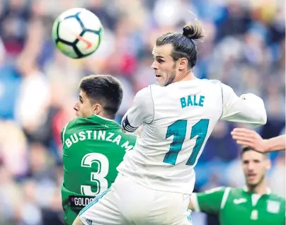  ??  ?? GALÉS. Gareth Bale, delantero de Real Madrid, conecta de cabeza ganándole en el salto a Unai Bustinza, defensa del Leganés.