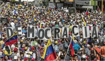  ?? Alejandro Cegarra / Bloomberg ?? Opposition demonstrat­ors protest Saturday in Caracas, Venezuela. Thousands of foes of the government marched in the capital as pressure builds for President Nicolás Maduro to resign.