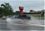  ?? (Pine Bluff Commercial/I.C. Murrell) ?? Rain flooded Dollarway Road and other streets across Pine Bluff on Tuesday, leaving drivers with little choice other than to splash through. This vehicle was seen going past the old Dollarway High School campus.