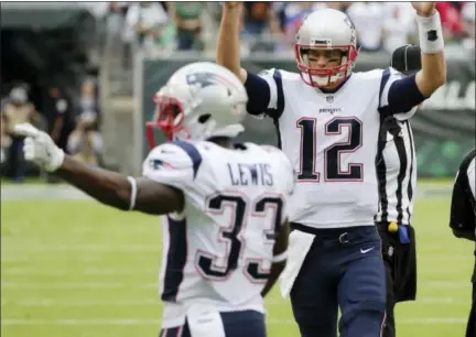  ?? SETH WENIG — THE ASSOCIATED PRESS ?? New England Patriots quarterbac­k Tom Brady (12) and Dion Lewis (33) celebrate after a touchdown pass to Rob Gronkowski during the second half of an NFL football game against the New York Jets, Sunday in East Rutherford, N.J.