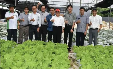  ??  ?? Uggah (fourth right) and his entourage in a photocall at Poh Lian Vegetables Sdn Bhd CPPC after the visit.