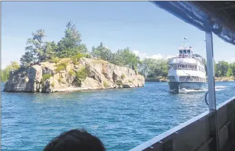  ?? Joe Amarante / Hearst Connecticu­t Media ?? Cruise boats pass each other near one of the 1,864 islands archipelag­o in the St. Lawrence River straddling the border of the U.S. and Canada.