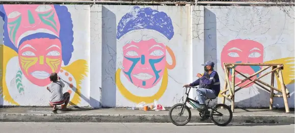  ?? PHOTOGRAPH COURTESY OF SMMPC ?? ARTISTS decorate the bare wall along Calle Real in Iloilo City ahead of the Dinagyang Festival next year.