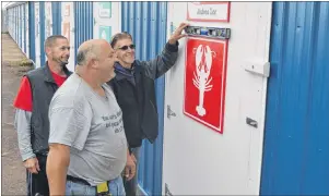  ?? ERIC MCCARTHY/JOURNAL PIONEER ?? Jody MacDonald, left, and project foreman Jason Greenan look on as Grant Buchanan confirms the sign on a storage shed door is level. The 30 storage sheds in two buildings on the West Point wharf were fixed up this year. All the sheds got new doors with...