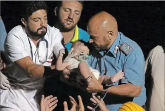  ?? THE ASSOCIATED PRESS ?? Firefighte­rs and rescuers rescue a boy from the collapsed building in Casamiccio­la, on the island of Ischia, near Naples, Italy, on Tuesday, a day after a 4.0-magnitude quake hit the Italian resort island.