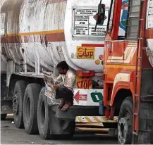  ?? Shailesh Andrade/Reuters ?? Motorista lê jornal em pneu de caminhão-tanque na Índia