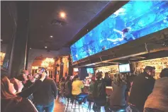  ??  ?? At Dive Bar, a 40-foot-long aquarium holds 7,500 gallons of saltwater - and the occasional mermaid.