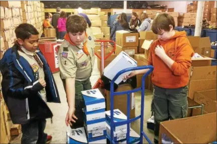  ?? EVAN BRANDT — DIGITAL FIRST MEDIA ?? Scouts from Troop and Pack 95, out of Cedarville United Methodist Church in North Coventry, were among the many volunteers who turned out for a Martin Luther King Jr.-inspired day of service over the weekend at In Ian’s Boots. Pictured from left sorting boxes Monday are Gabriel Gonzalez, Michael Wingert and Justin Cahoe.