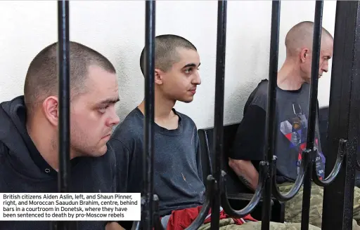  ?? ?? British citizens Aiden Aslin, left, and Shaun Pinner, right, and Moroccan Saaudun Brahim, centre, behind bars in a courtroom in Donetsk, where they have been sentenced to death by pro-moscow rebels