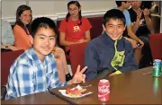  ?? Doug Walker / Rome News-Tribune ?? Motoki Murakami (left) and Shunsuke Murakami enjoy a few snacks during a welcoming ceremony for Japanese middle school students on an exchange trip.