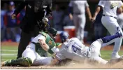  ?? JED JACOBSOHN — THE ASSOCIATED PRESS ?? The Rangers' Eli White (41) slides safely into home plate as A's catcher Sean Murphy, front left, applies the tag on a ball hit by the Rangers' Brad Miller during the eighth inning on Saturday in Oakland.