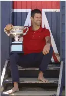  ??  ?? Djokovic poses with the trophy