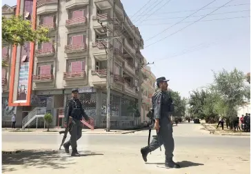  ?? — Reuters photos ?? Afghan policemen arrive at the site of an attack in Kabul.