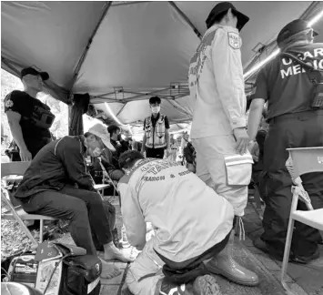  ?? AGENCE FRANCE PRESSE ?? A member of a search and rescue team provides medical care to a man, who was evacuated from the Taroko area, in a makeshift clinic in Hualien, after a major earthquake hit Taiwan’s east.
