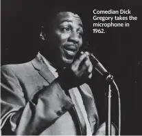  ?? Three Lions/Getty Images/TNS ?? Comedian Dick Gregory takes the microphone in 1962.