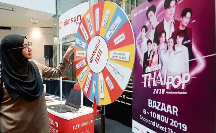  ??  ?? Wheel of fun: teacher Nurul Ihsan atiqah Jamal, 34, having a go at picking a prize at the dimsum booth at the thai Pop bazaar in Central i-City, Shah alam.